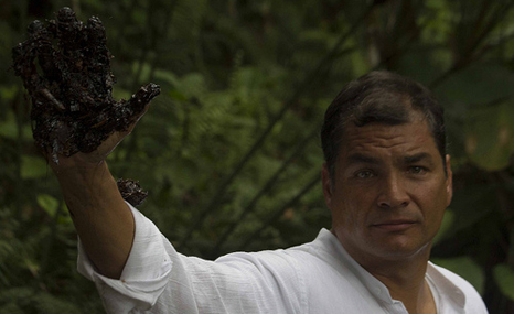 Ecuador President Correa holds up an oil-stained hand after visiting dumping grounds in the Amazon jungle (Pic: Fernando Alvadaro)