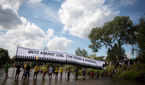 Demonstrators linked hands across the Polish-German border in the Neisse River (Pic: Greenpeace/Gordon Welters)