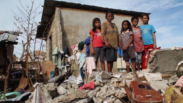 Corazon dela Cruz and her four children in the wreckage of their home destroyed by Typhoon Haiyan (Pic: Pio Arce/Genesis Photos - World Vision)