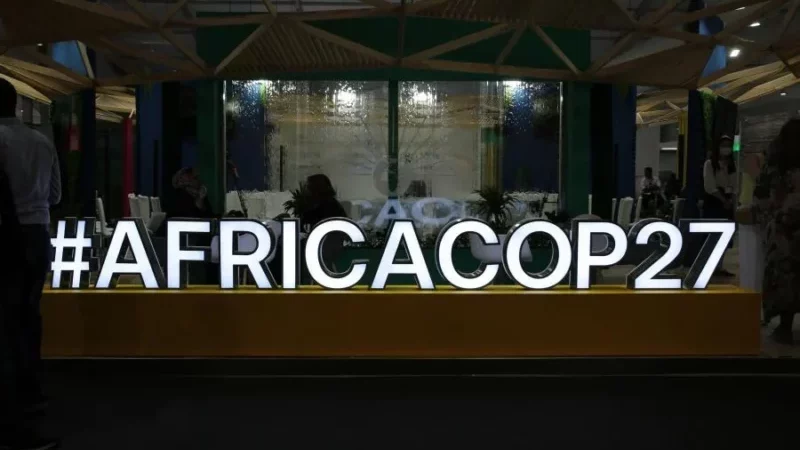 a neon sign says #AFRICACOP27
