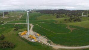wind turbines and construction equipment on green hills