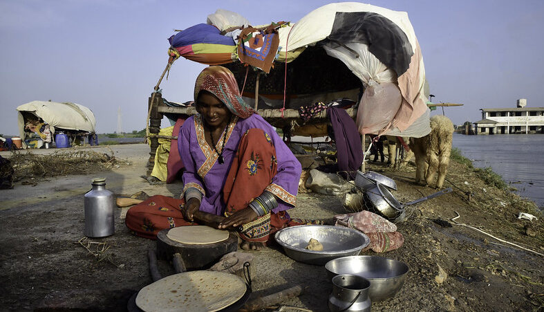 A woman cooks bread outside her tent.