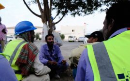 Group of migrant workers chatting by a road in the UAE