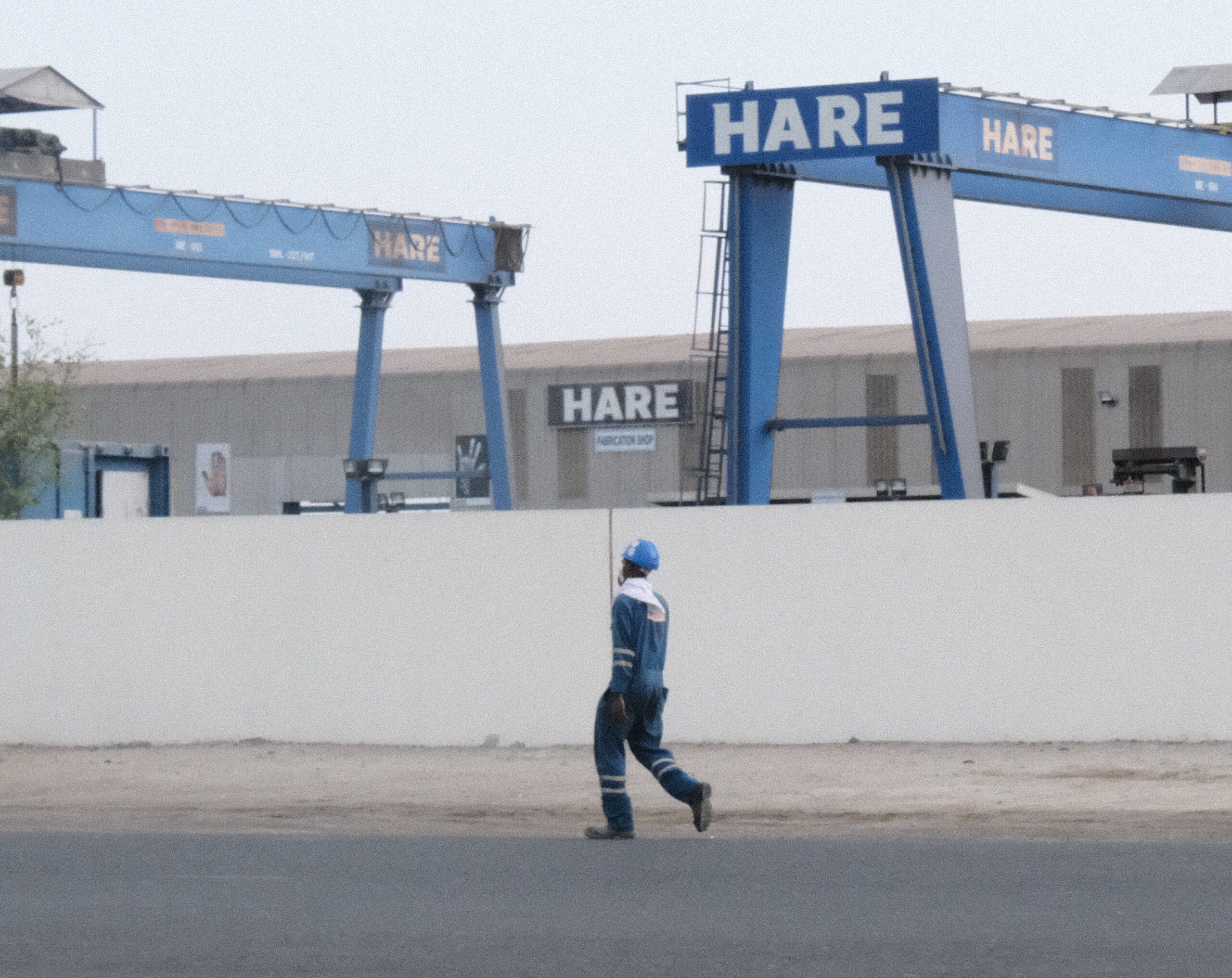 An Adnoc worker walking by an oil and gas project