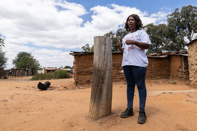 Nelly Sigudha, a worker in the coal sector, stands in an informal settlement by the Duvha power station.
