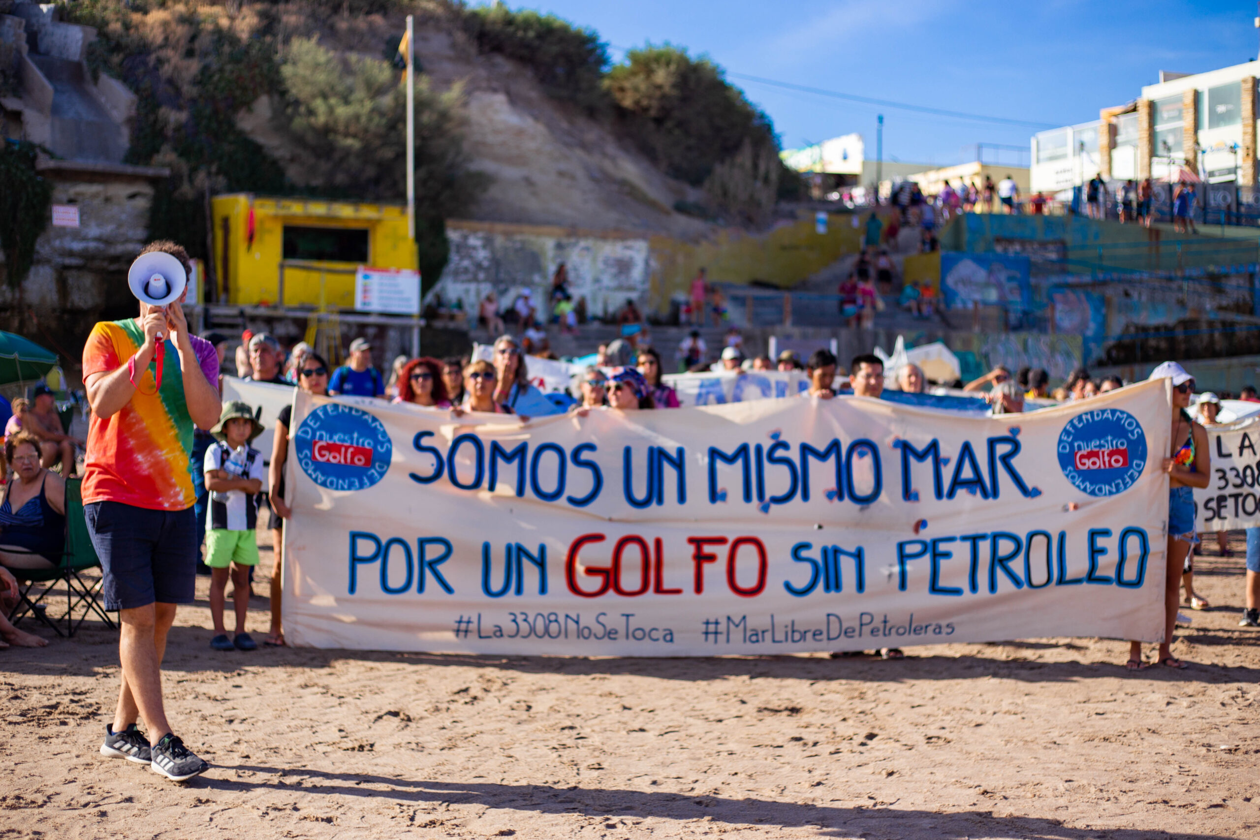 A group of dozens of activists holding a sign in a demonstration against the Vaca Muerta gas terminal