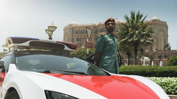 Fearing repression, non-binary people stay away from Cop28. A police officer in Abu Dhabi poses with his police car