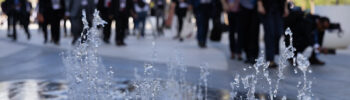 a water feature and people in suits walking through the Cop28 climate conference venue