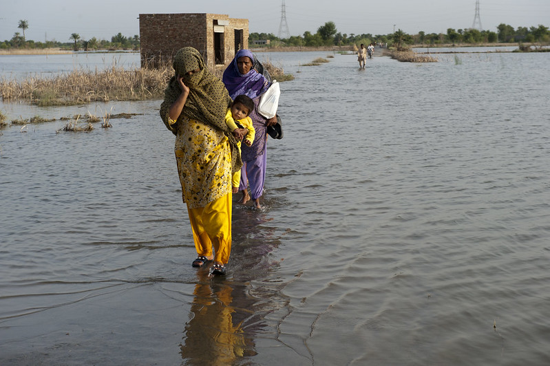 A family crosses the flooded streets of Pakistan. Photo: Asian Development Bank